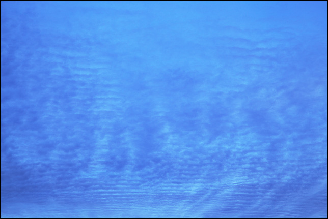 Abstract photograph of broken dark blue clouds on a light blue sky near sunset. Photographed in Fort Wayne, Indiana.