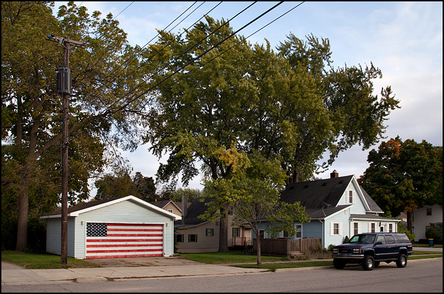 A large handpainted American flag completely covers the front door of a garage behind a house on Christyann Street in Mishawaka Indiana.