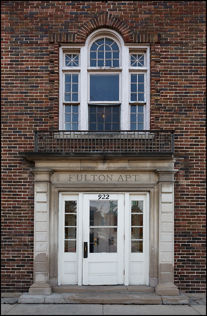 The Georgian style entrance to Fulton Apartments, a brick apartment building on Fulton Street in downtown Fort Wayne, Indiana.
