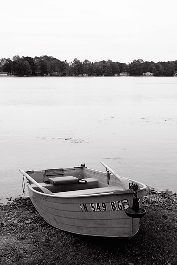 An aluminum rowboat with oars on the beach at Loon Lake in northeast Indiana.
