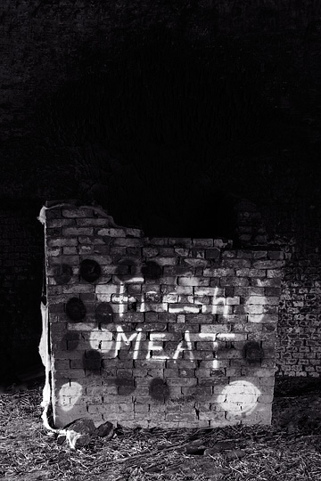 Spray painted colored spots and graffiti that says Fresh Meat inside a beehive kiln at the abandoned brick factory in Medora, Indiana.