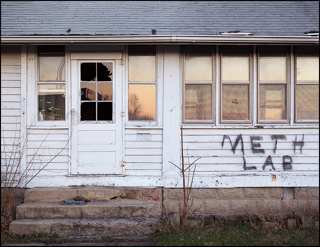 An abandoned house with graffiti painted under the window that says Meth Lab. The house is on Bluffton Road in the Waynedale area of Fort Wayne, Indiana.