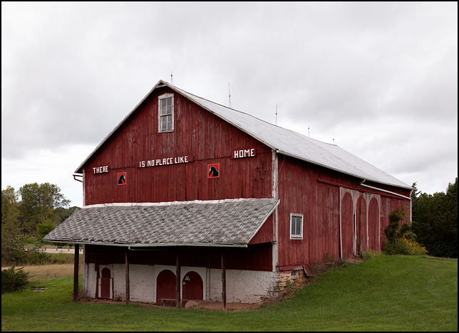 An old red barn on a farm in rural Indiana with a sign that says There Is No Place Like Home.