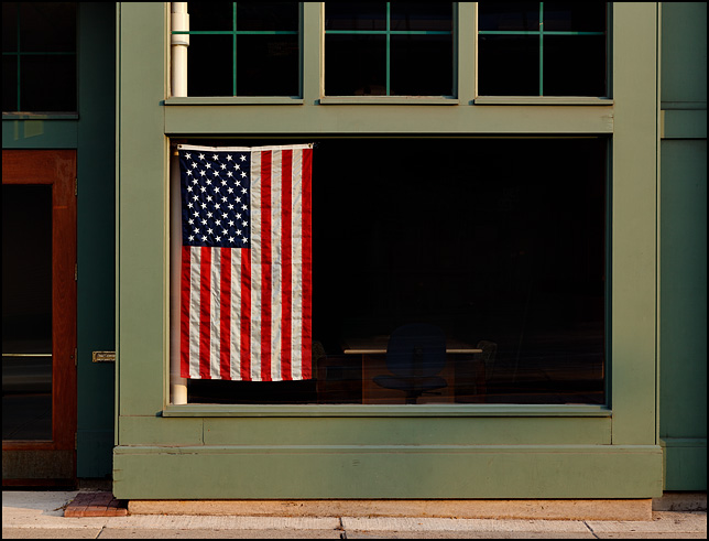 A large American flag in the front window of an office on Main Street in Fort Wayne, Indiana.
