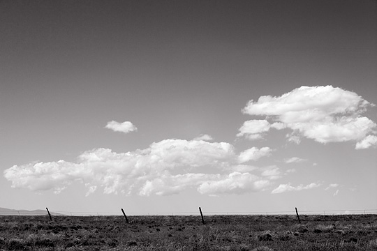 Barbed wire fence under a big sky on the high desert plains of New Mexico along the Turquoise Trail.
