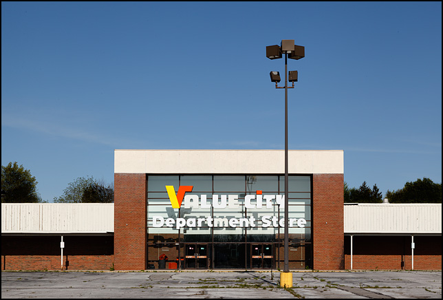 An abandoned Value City Department Store sits in a crumbling parking lot in Fort Wayne, Indiana.