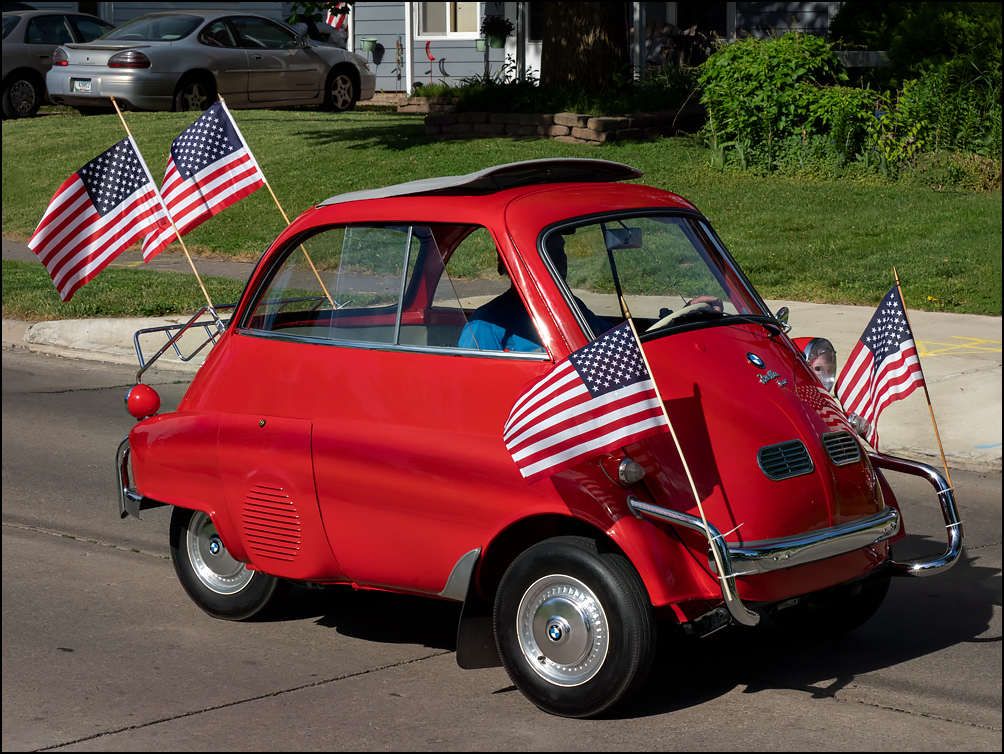 A red 1957 BMW Isetta 300, decorated with American flags at the 2023 Waynedale Memorial Day Parade in the Waynedale area of Fort Wayne, Indiana.
