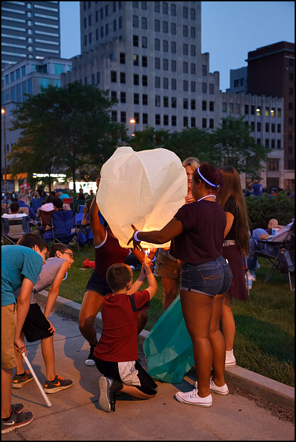 A group of teenagers lighting a sky lantern hot-air balloon before the Fourth of July Fireworks on the Courthouse Green in downtown Fort Wayne, Indiana.