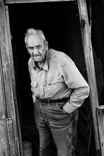 Elderly farmer Richard Youse standing in the doorway of his weathered old house in rural Allen County, Indiana.