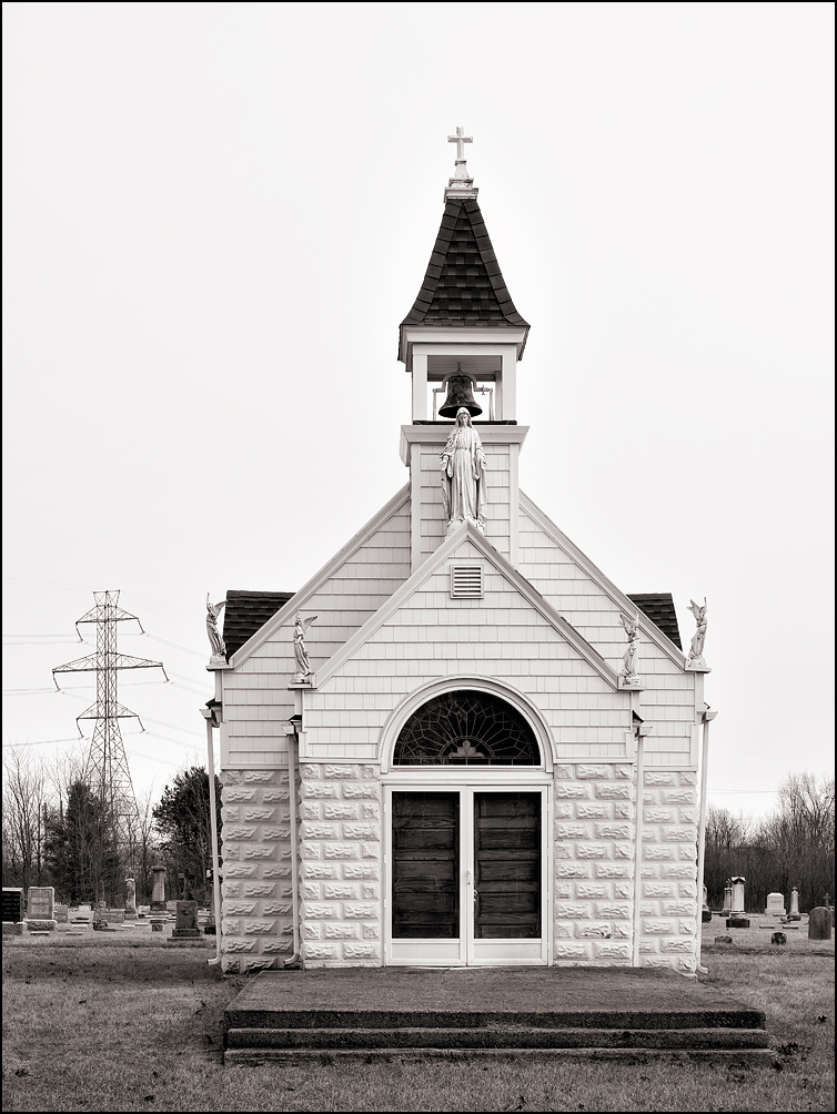 A tiny white chapel with statues of the Virgin Mary stands in the middle of Saint Marys Cemetery outside the small town of Avilla, Indiana.