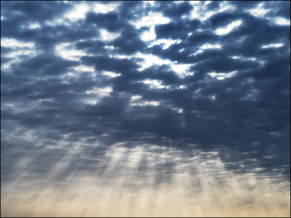 Rays of light radiating out from the clouds in the morning sky over Fort Wayne, Indiana.