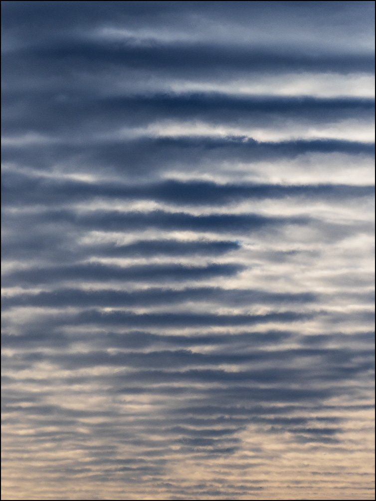 Abstract photograph of bands of dark clouds filling the morning sky over Fort Wayne, Indiana.