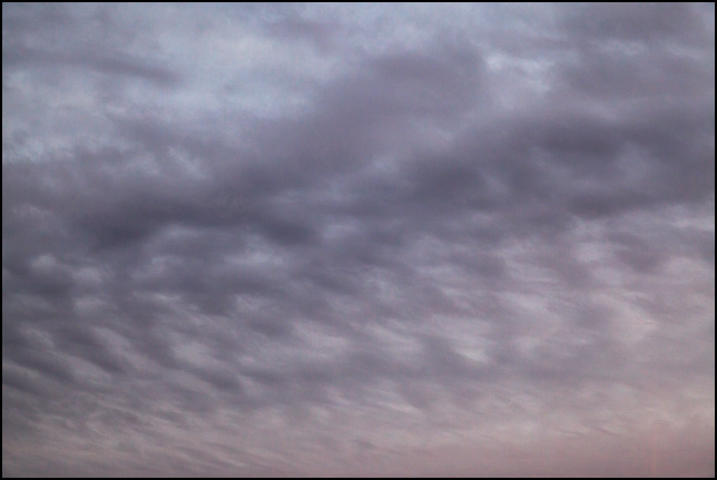 Abstract photograph of a spotted and striped pattern of dark clouds in a gray sky on a November evening in rural Allen County, Indiana.