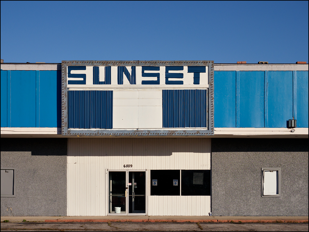 Sunset Hall, a former movie theater turned into a music venue and dance hall on South Hanna Street in Fort Wayne, Indiana. The rundown old theater has a hand-painted sign that says SUNSET.