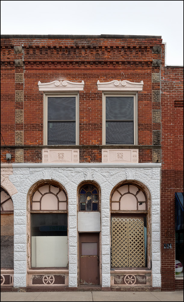The side of the Schneider Building on Main Street in the small town of Antwerp, Ohio. The brick and stone building has arched windows on the first floor.