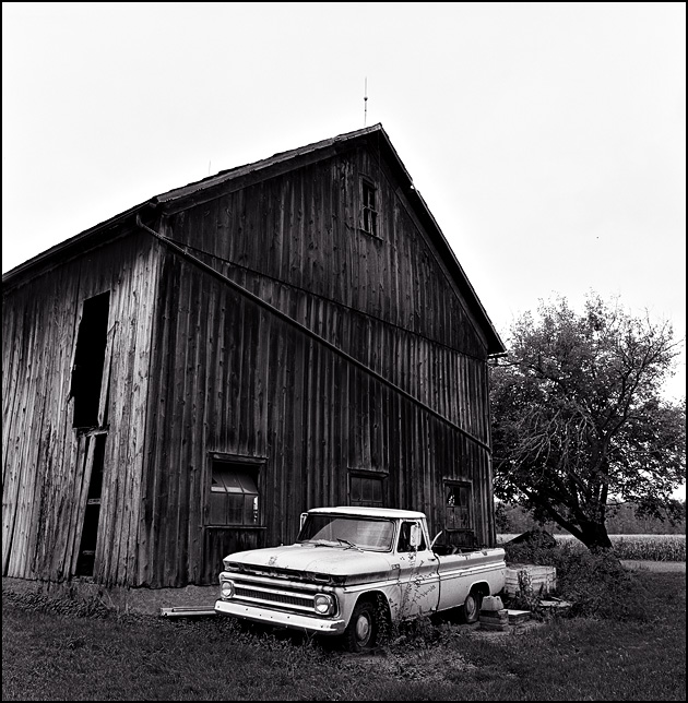 A 1965 Chevrolet pickup truck sitting next to an abandoned barn on a farm in rural Indiana.