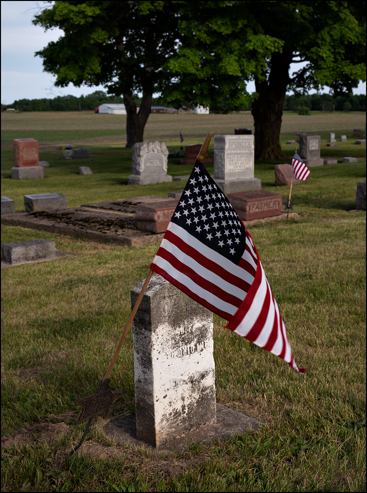A large American flag mounted on a Grand Army Of The Republic star at a Civil War Veterans grave in the Christian Union Cemetery in rural DeKalb County, Indiana.