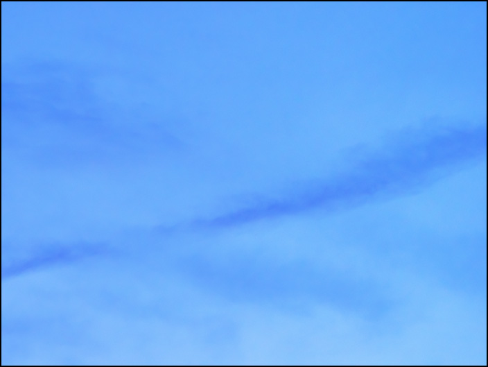 An abstract photograph of long dark clouds crossing in the sky at dusk on a May evening in Fort Wayne, Indiana.