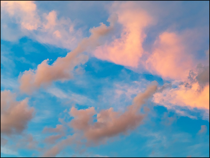 An abstract photograph of lines of clouds forming a diamond shape in the sky at sunset in Fort Wayne, Indiana.