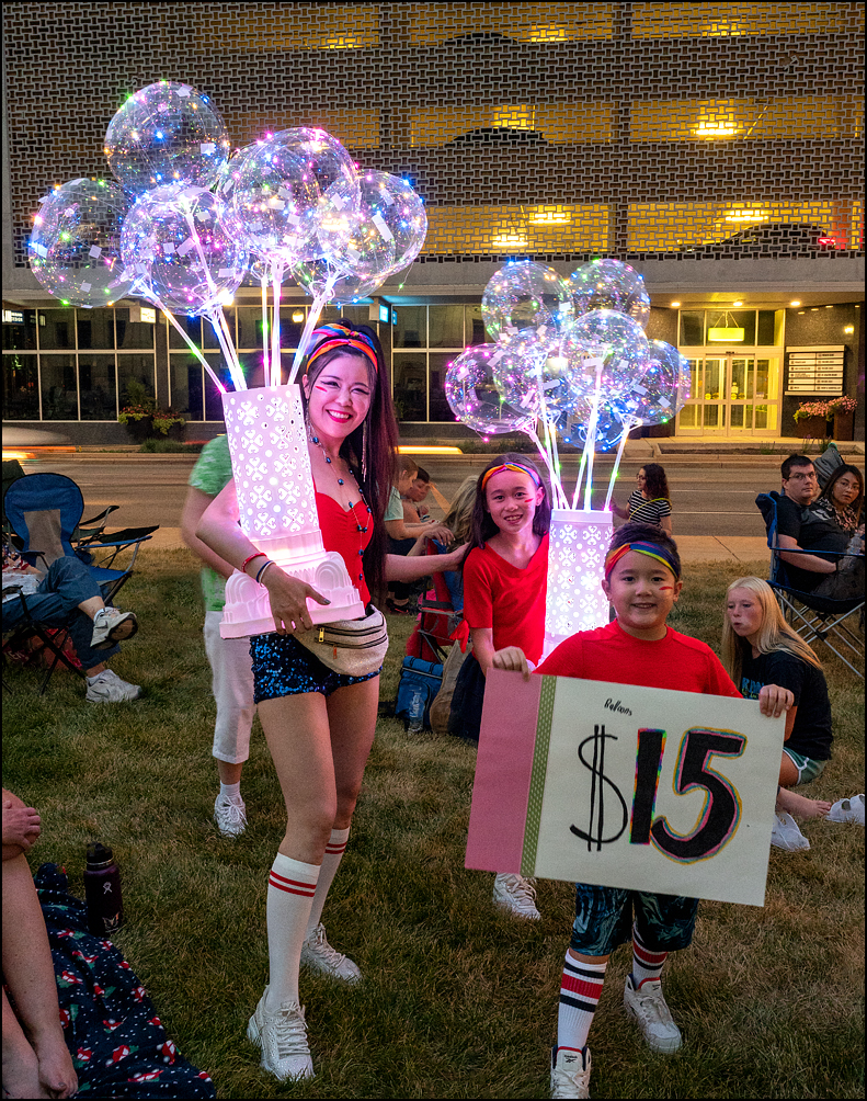 Asian kids selling lighted balloons at the 2022 Fourth of July fireworks in downtown Fort Wayne, Indiana.