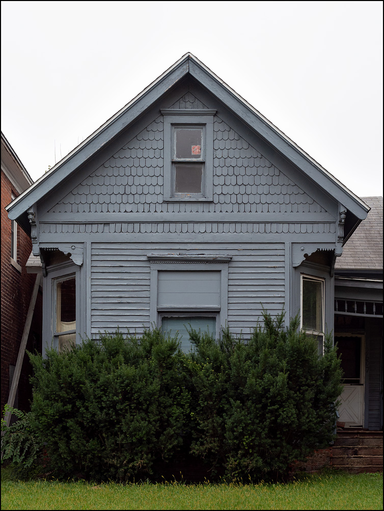 A small gray house decorated with Victorian gingerbread moldings on Broadway in Fort Wayne, Indiana.