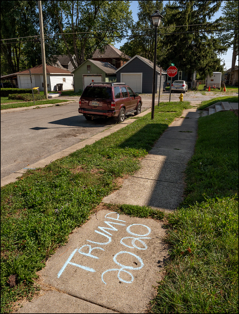 Trump 2020 graffiti written in blue chalk on a sidewalk on Cortland Avenue in Fort Wayne, Indiana.
