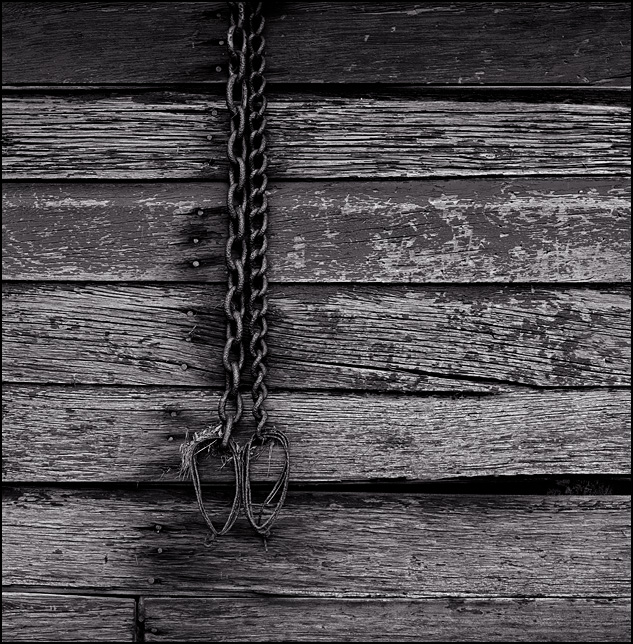 A pair of rusty chains hang on the side of a weatherbeaten old barn in rural Allen County, Indiana.