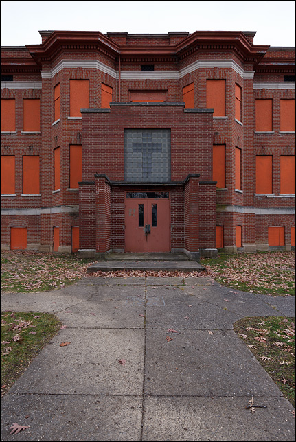 A boarded up dormitory building at the former Fort Wayne Bible College and Taylor University campus in Fort Wayne, Indiana. The glass bricks above the entrance form a large cross over the doors.