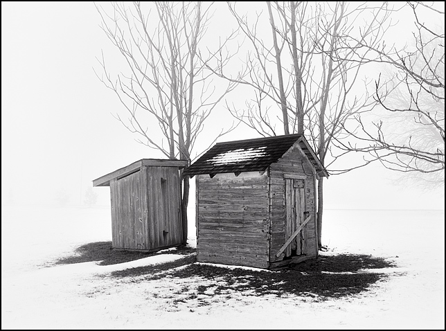 Heavy winter fog over an outhouse and a small shed in the snow on a farm in southwest Allen County, Indiana.