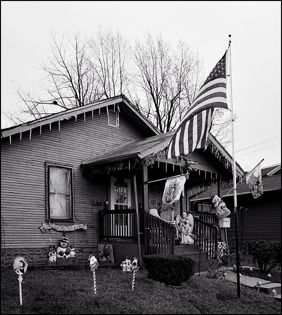 The American flag flies waves in front of a little house covered in Christmas decorations in an inner-city neighborhood in Fort Wayne, Indiana.