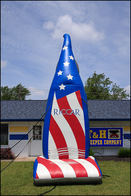 A giant inflatable Riccar vacuum cleaner, colored like the American flag, stands in front of T&H Sweeper Company in Muncie, Indiana.