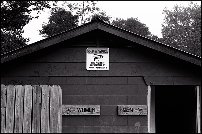 The sign above the entrance to a public restroom says that the premises are under video surveillance. Located in Memorial Park in Lebanon, Indiana.
