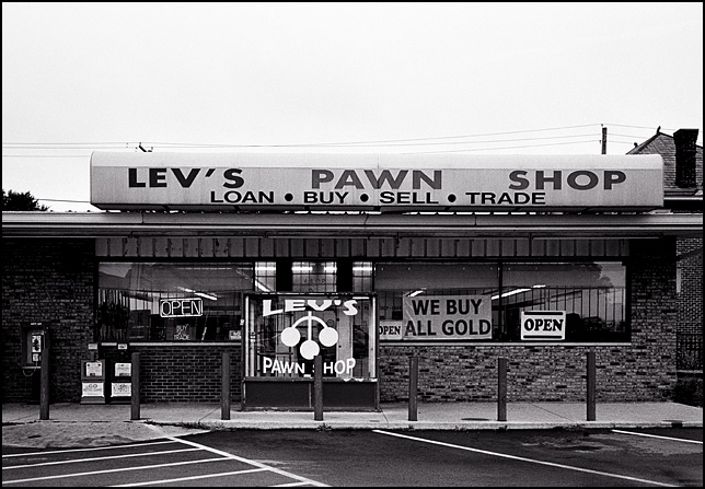 Levs Pawn Shop on Wells Street in Fort Wayne, Indiana with signs in the windows that say they buy all gold.