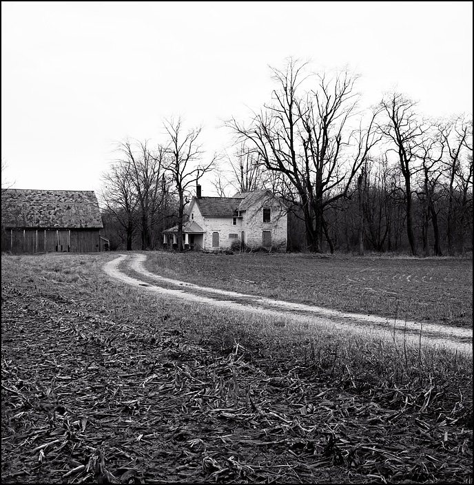 A long winding driveway leads back to an abandoned farmhouse and barn on Lower Huntington Road in rural Allen County, Indiana.
