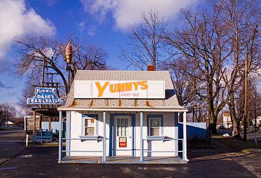 Yummy's Dairy Bar in Clarksville, Indiana is a small town ice cram stand with an old fashioned sign shaped like an ice cream cone.