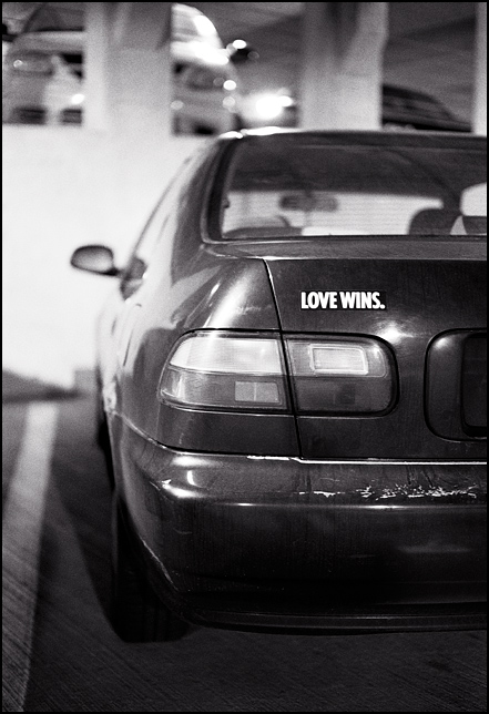 A car with a bumper sticker that says Love Wins.