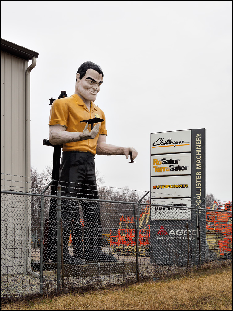 A giant fiberglass Muffler Man statue standing next to I-69 at MacAllister Rentals outside Muncie, Indiana.