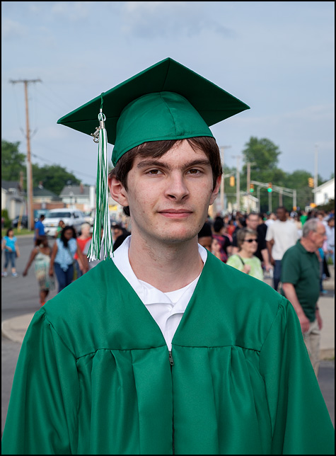 Portrait of MacKenzie Crawford graduating from high school in his green South Side High School cap and gown.
