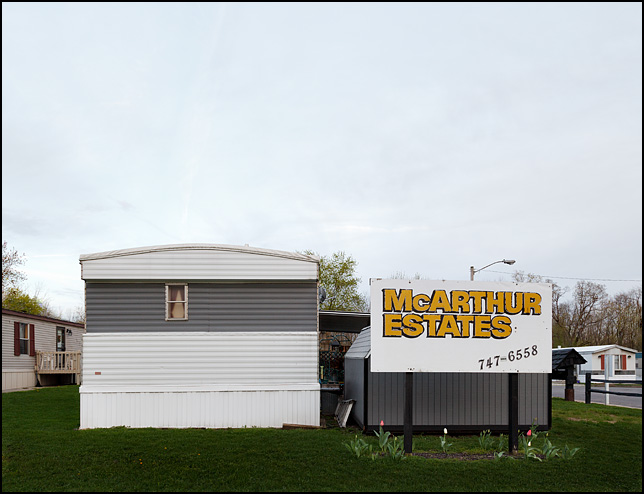 The sign at the entrance of McArthur Estates trailer park in the Waynedale section of Fort Wayne stands in front of a mobile home and toolshed.