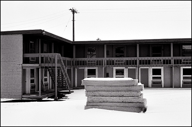 A stack of old mattresses covered in snow stands in the middle of the parking lot of Nortons Motel, an abandoned hotel on Maumee Avenue in Fort Wayne, Indiana.