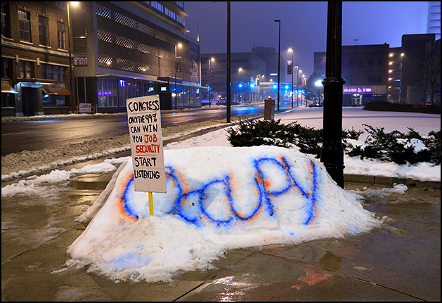 An Occupy Fort Wayne sign stuck in a snowbank in front of the Allen County Courthouse in Fort Wayne, Indiana. The sign says Congress, only the 99 percent can win you job security, start listening.