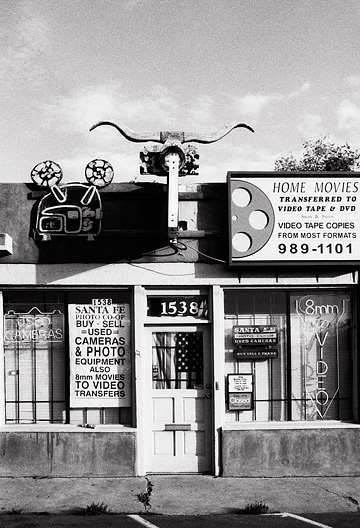 An American flag hangs in the window on the door of the Santa Fe Photo Co-Op camera store, and a set of bull horns hangs over the front door.