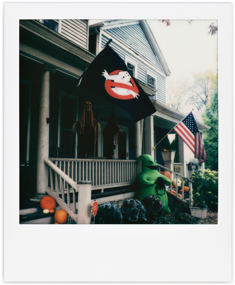 Polaroid snapshot of a house decorated for Halloween with a big green ghost holding a spider standing in front of the porch under a Ghostbusters flag. Washington Boulevard in the West Central neighborhood in Fort Wayne, Indiana.