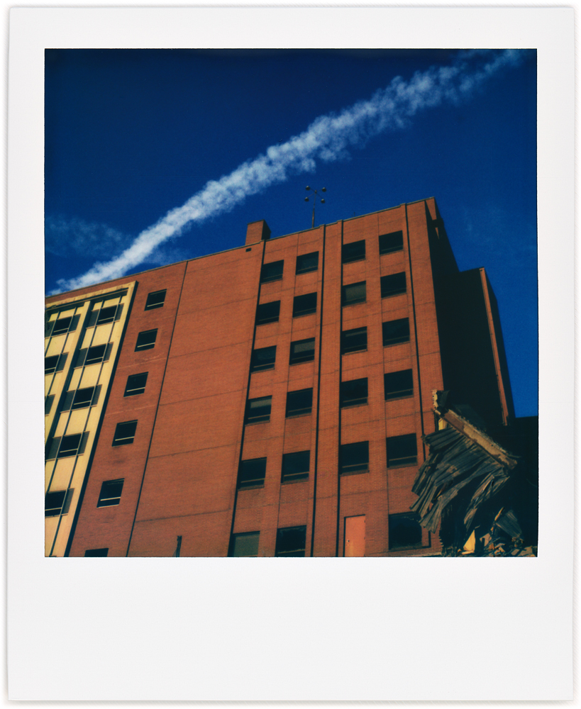 A Polaroid photo of the front of Saint Joseph Hospital in downtown Fort Wayne, Indiana. The hospital is being demolished but only a small part of this section has been taken down.