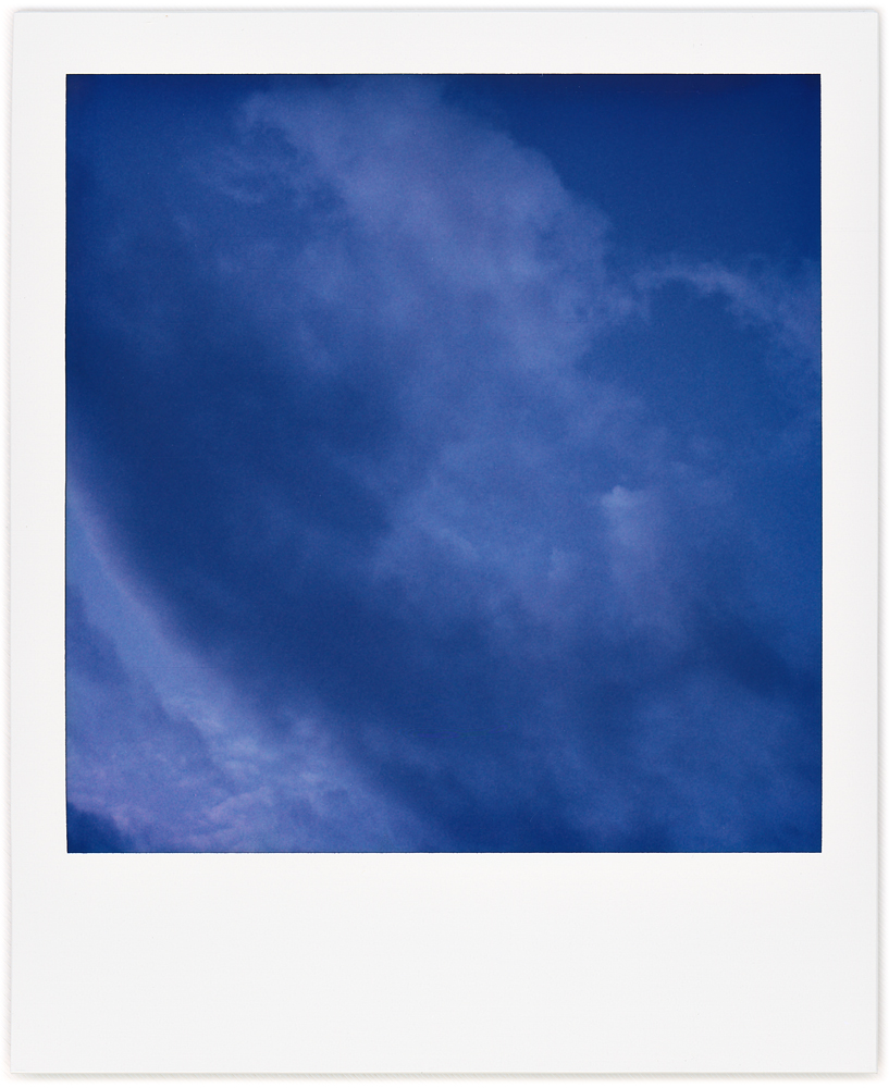 Polaroid abstract photograph of clouds swirling in the early morning sky.