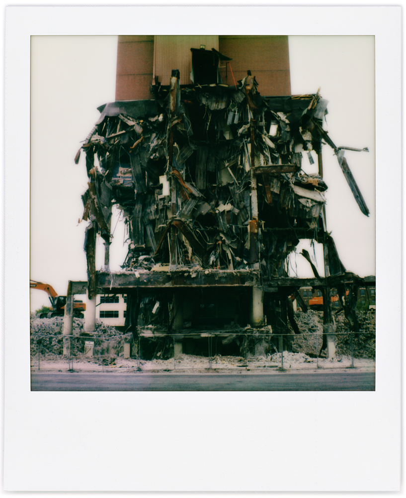 A Polaroid photo of the partially demolished of the north side of Saint Joseph Hospital in downtown Fort Wayne, Indiana. The lower floors are destroyed but the upper floors are still intact.