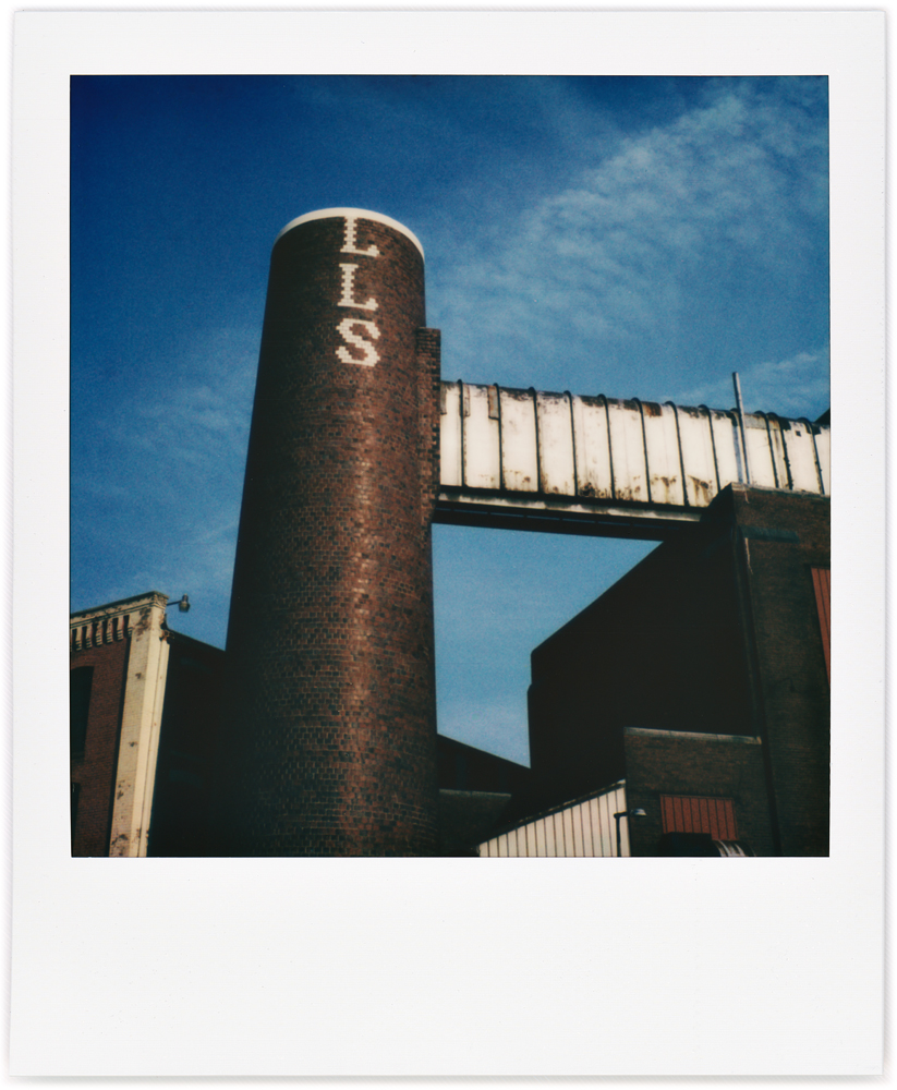 Polaroid snapshot of the old brick factory buildings and chimney at the former Wayne Knitting Mills on Growth Avenue in Fort Wayne, Indiana.