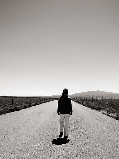 Self Portrait of Christopher Crawford walking on Waldo canyon Road in the New Mexico desert. The Ortiz Mountains are visible in the background.