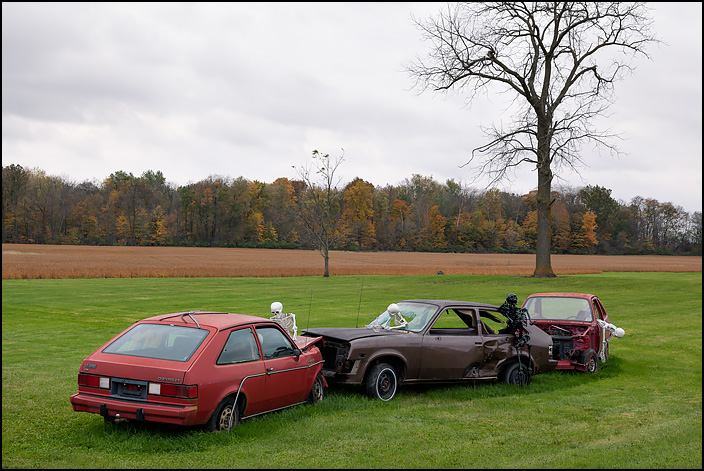 Three old wrecked Chevrolet Chevettes crashed together with skeleton drivers as a Halloween decoration in front of a house on State Route 2 in rural Defiance County, Ohio.