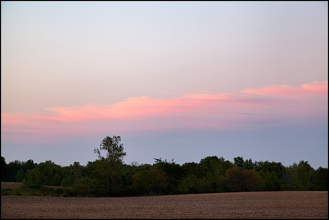 A streak of red clouds in the sky at sunset over a field on US-33 in rural northwest Allen County, Indiana.